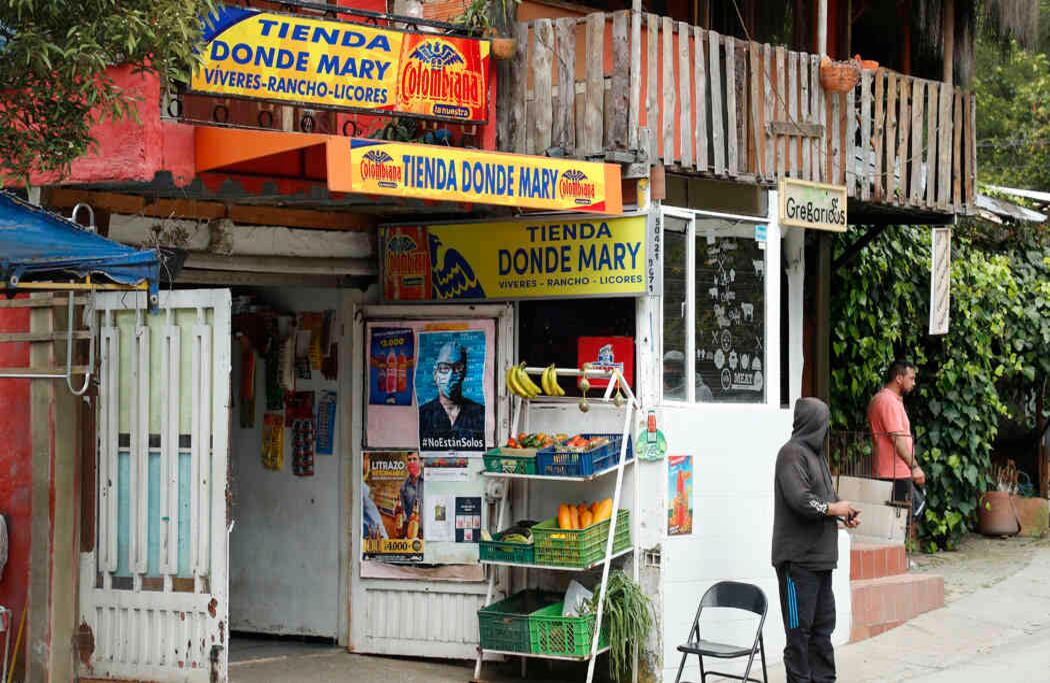 En Bogotá, los propietarios de una tienda de barrio exhiben en afiche de la campaña, una muestra de que el país está con todos aquellos que hoy luchan contra el covid-19. 