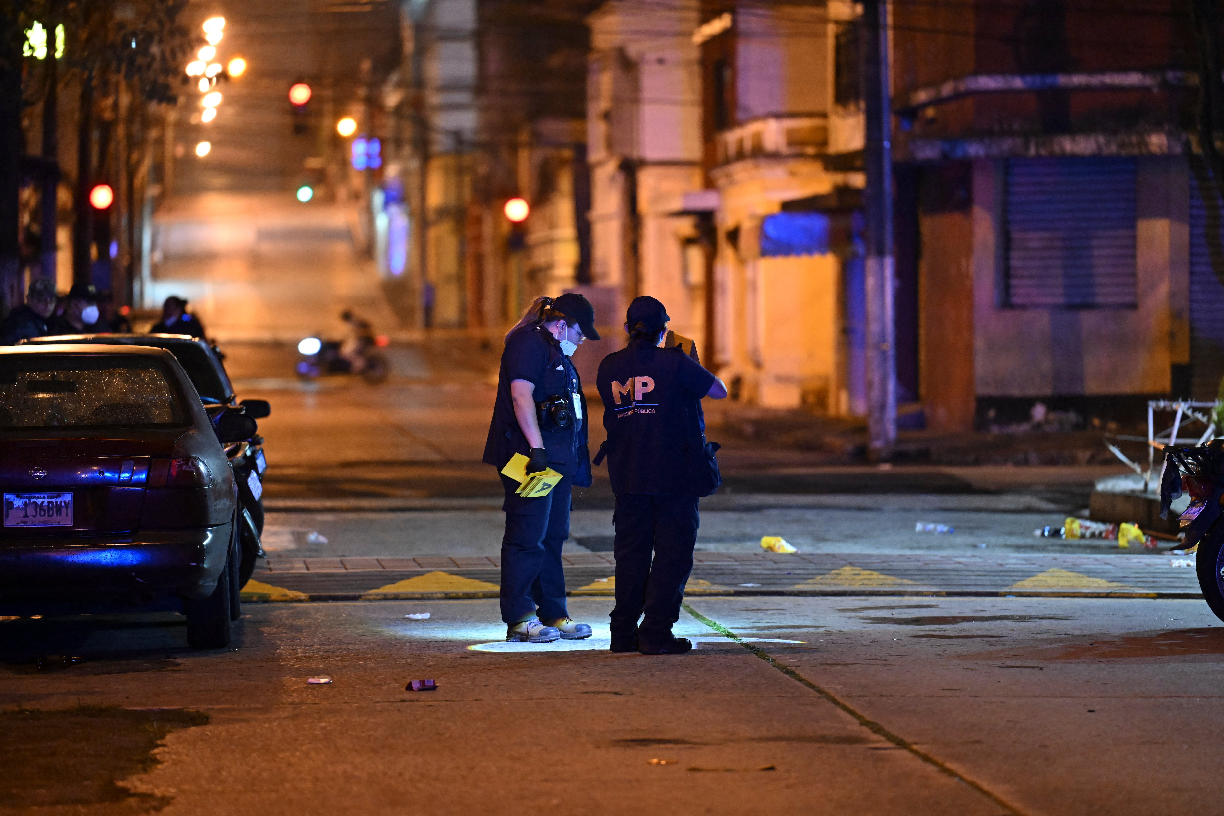 Miembros del Ministerio Público buscan evidencias junto a la escena del crimen donde siete personas fueron asesinadas en un ataque perpetrado por presuntos pandilleros en una funeraria en la Ciudad de Guatemala el 30 de julio de 2025.