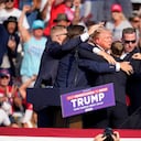 Republican presidential candidate former President Donald Trump is helped off the stage at a campaign event in Butler, Pa., Saturday, July 13, 2024. (AP Photo/Gene J. Puskar)