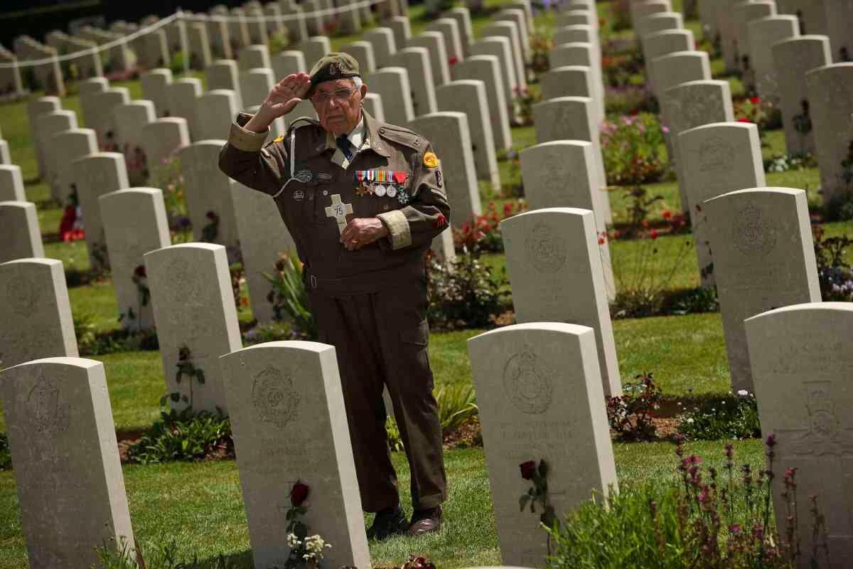 6 de junio - Un veterano de la Segunda Guerra Mundial saluda mientras posa para una fotografía al final de una ceremonia para conmemorar el 75 aniversario del Día D en el Cementerio de Guerra de Bayeux en Bayeux. Fotógrafo: Francisco Seco / AP