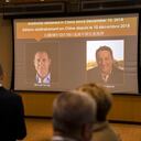 A video screen displays images of Canadians Michael Kovrig, left, and Michael Spavor at an event held in connection with the announcement of the sentence for Spavor at the Canadian Embassy in Beijing, Wednesday, Aug. 11, 2021. A Chinese court has sentenced Spavor to 11 years on spying charges in case linked to Huawei. (AP Photo/Mark Schiefelbein)