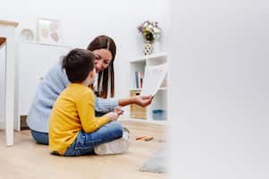 Terapeuta profesional en educación infantil hablando sobre la familia con un niño en un centro de apoyo familiar. Terapia mental para niños