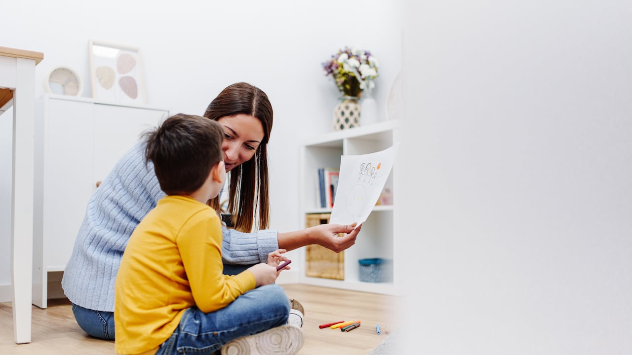 Terapeuta profesional en educación infantil hablando sobre la familia con un niño en un centro de apoyo familiar. Terapia mental para niños