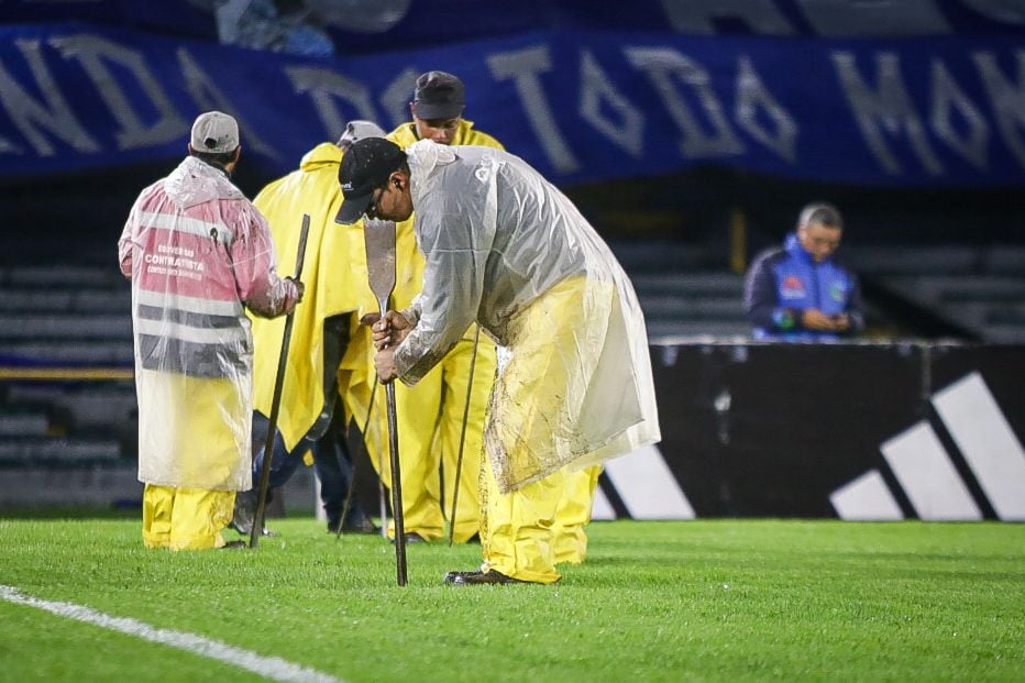 Trabajadores del Estadio El Campín realizan sus operaciones para ayudar con el drenaje de la cancha.