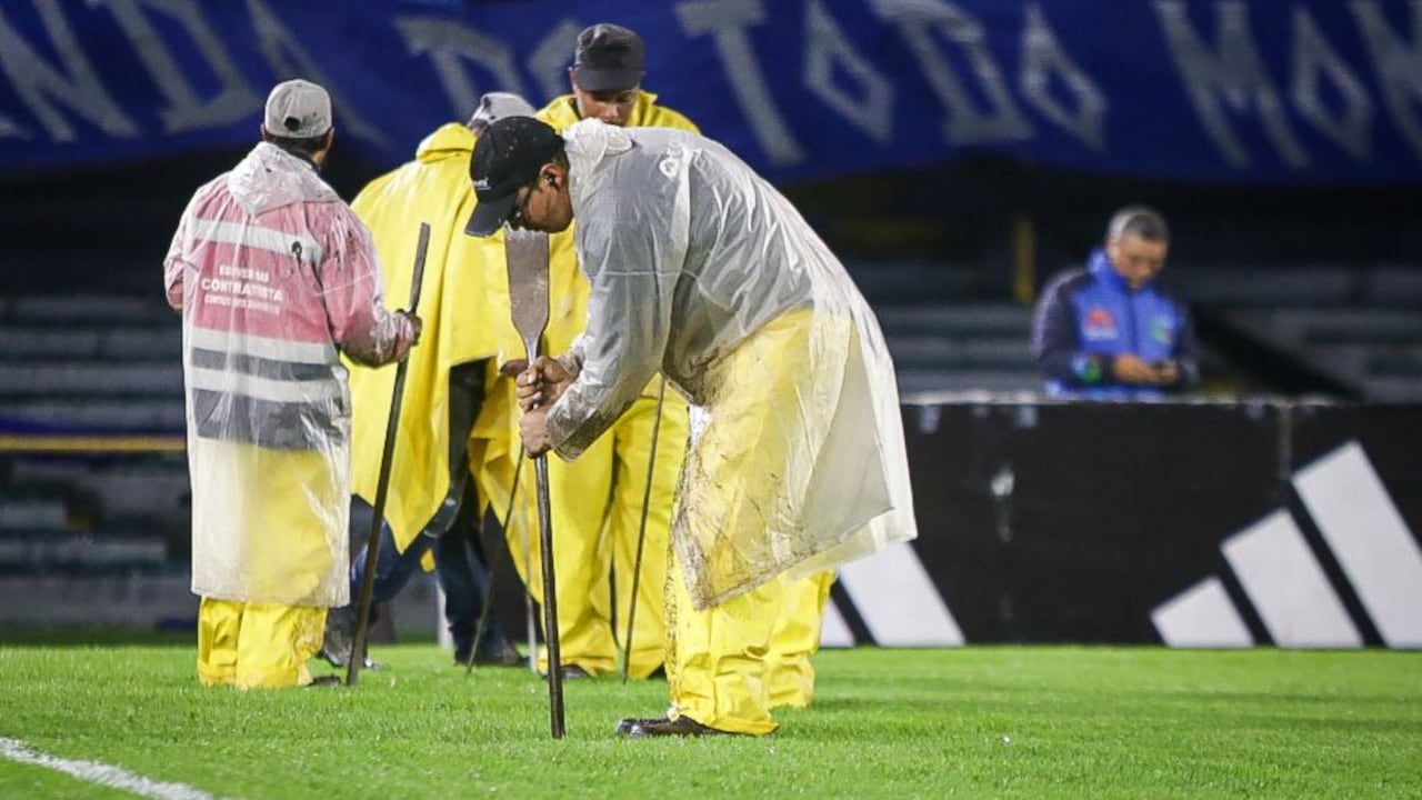 Trabajadores del Estadio El Campín realizan sus operaciones para ayudar con el drenaje de la cancha.