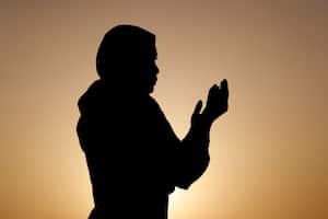 Silueta de mujer musulmana en abaya rezando con las manos en el aire al atardecer. Concepto de oración religiosa. Emiratos Árabes Unidos. (Foto de: Philippe Lissac/Godong/Universal Images Group vía Getty Images)