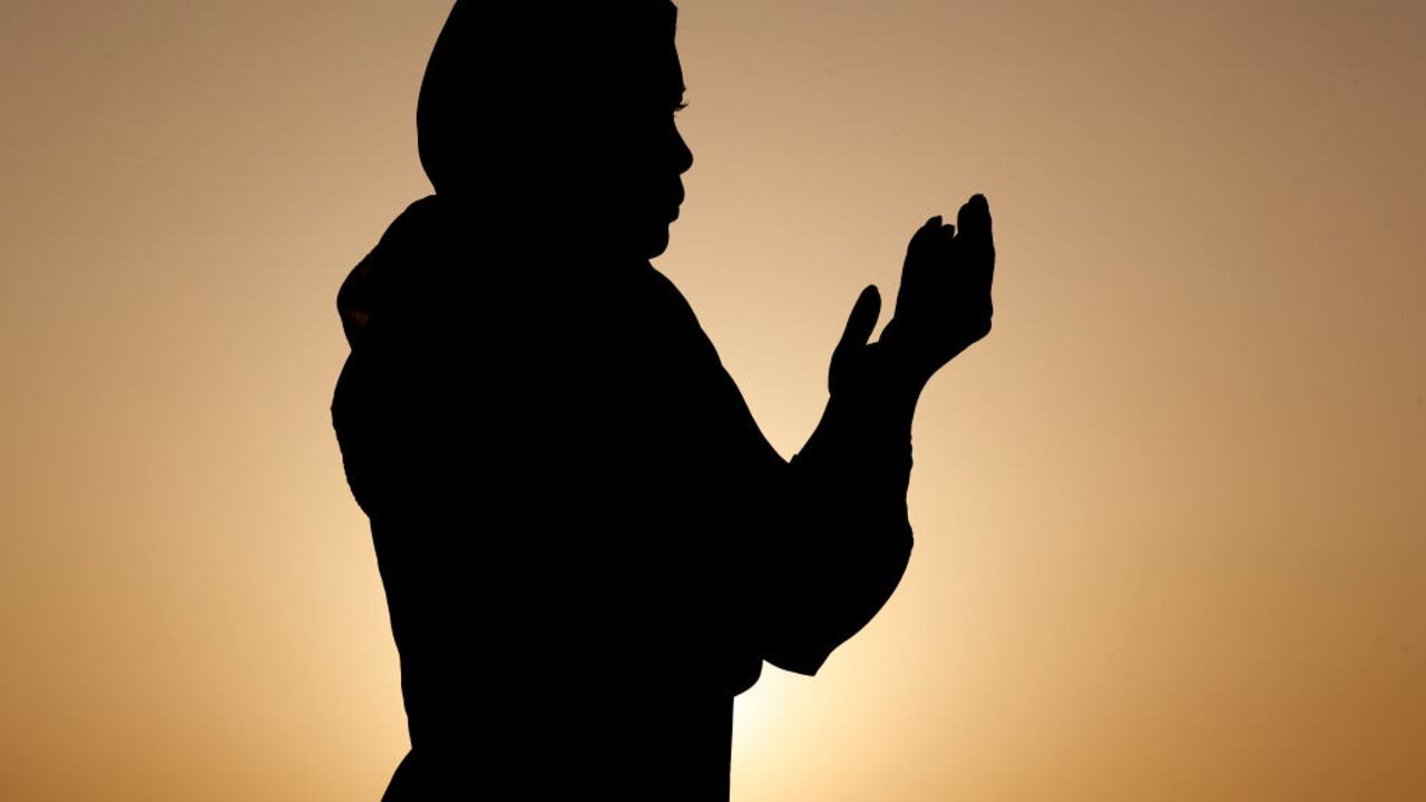 Silueta de mujer musulmana en abaya rezando con las manos en el aire al atardecer. Concepto de oración religiosa. Emiratos Árabes Unidos. (Foto de: Philippe Lissac/Godong/Universal Images Group vía Getty Images)