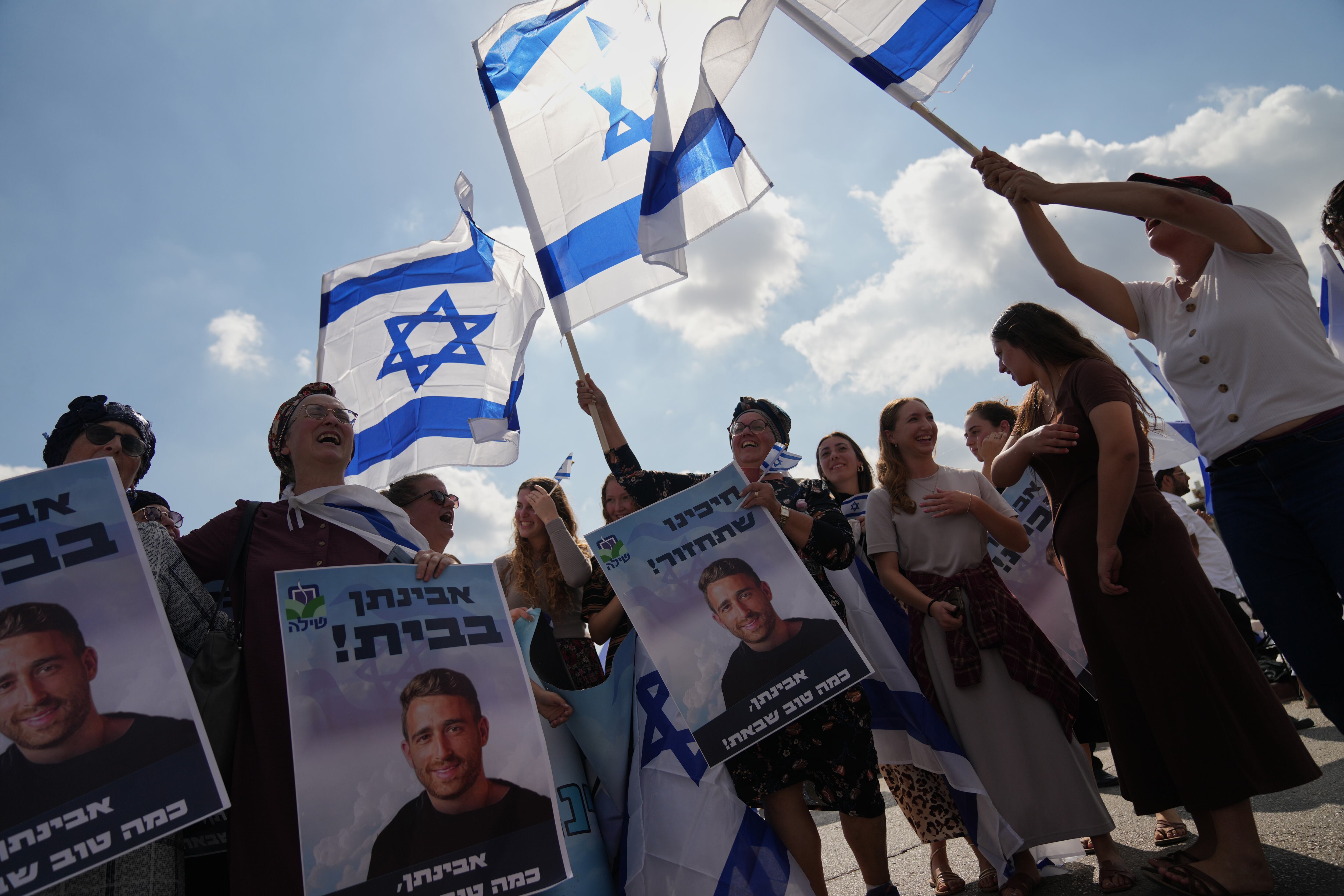 La gente ondea banderas israelíes en señal de celebración mientras esperan afuera del Hospital Beilinson en Petah Tikva, Israel, la llegada de algunos de los secuestrados liberados.
