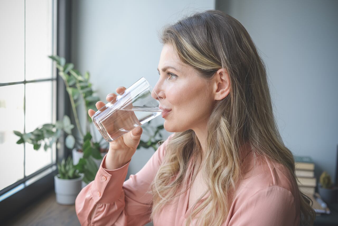 attractive middle aged woman in the office ( drinking water)