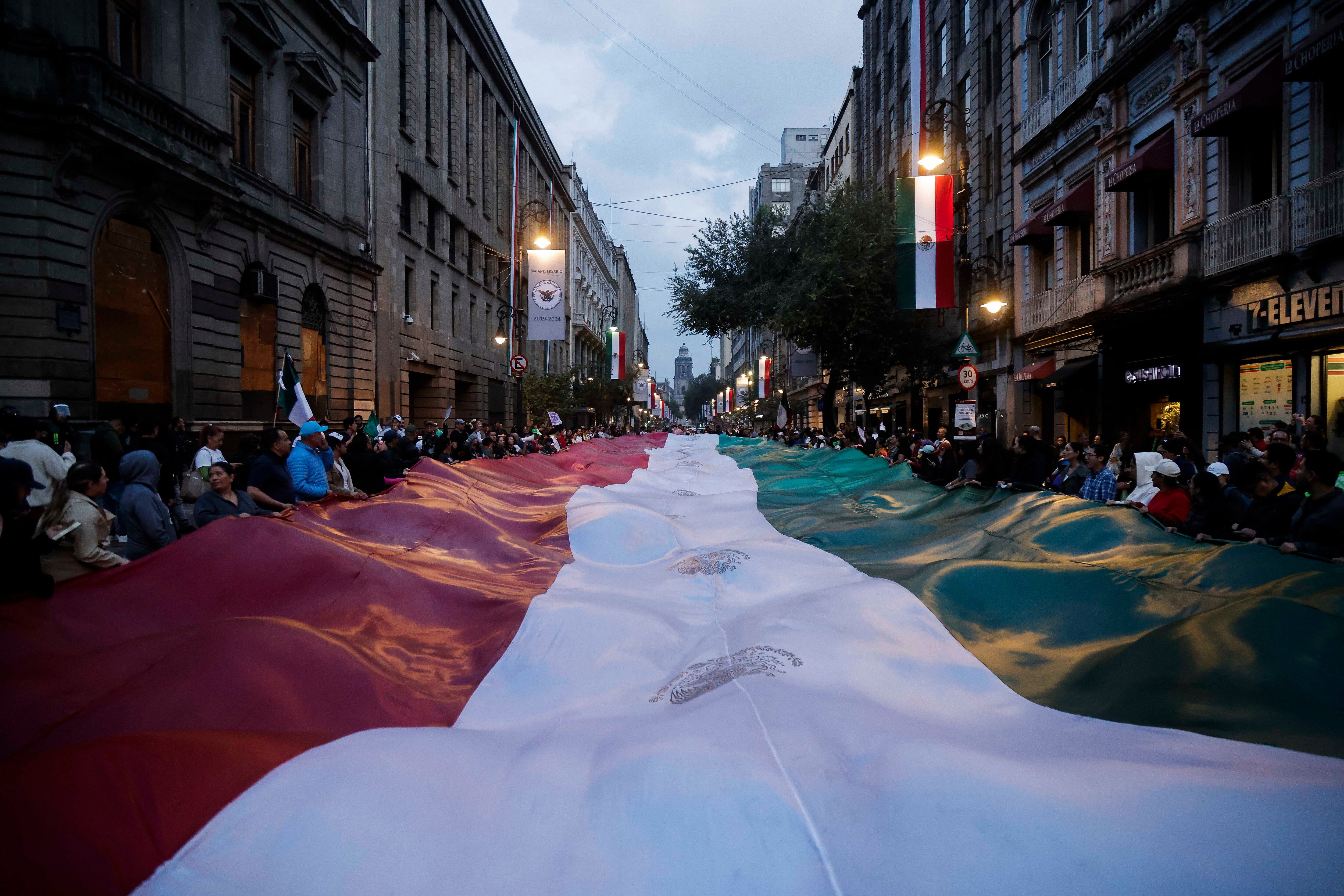 Los trabajadores judiciales sostienen una bandera gigante mientras bloquean las calles cerca de la antigua sede del Senado de México, conocida como Casona de Xicotencatl, durante una protesta en la Ciudad de México el 10 de septiembre de 2024. El Senado de México aprobó el 11 de septiembre una reforma constitucional para permitir los votantes elegirán jueces, anunció la cámara, después de que los manifestantes obligaran anteriormente a los legisladores a suspender el debate sobre la propuesta.