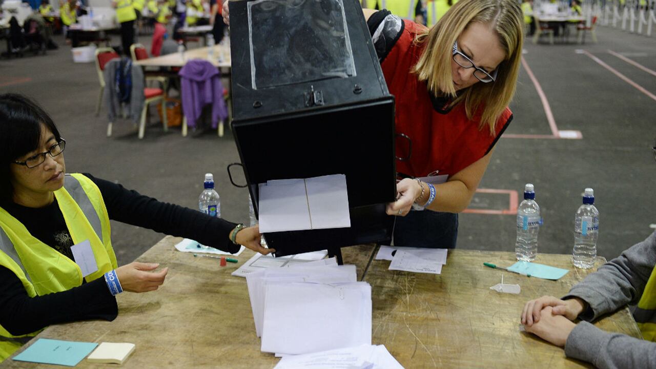 Una mujer abre una urna con votos en Edimburgo, Escocia Reino Unido.