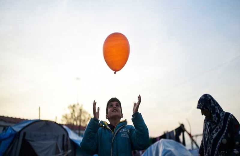 Un chico juega con un globo en el improvisado campo de refugiados en la frontera entre Grecia y Macedonia. Más de 50.000 refugiados están atrapados en el lado griego, a la espera de que los controles migratorios les permitan adentrarse en Europa.