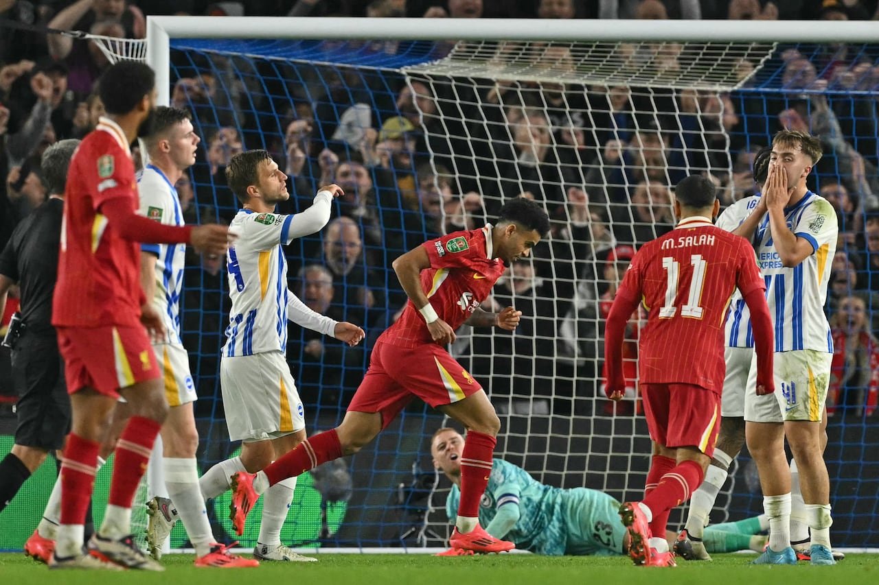 Liverpool's Colombian midfielder #07 Luis Diaz (C) celebrates after scoring their third goal during the English League Cup round of 16 football match between Brighton and Hove Albion and Liverpool at the American Express Community Stadium in Brighton, southern England on October 30, 2024. (Photo by Glyn KIRK / AFP) / RESTRICTED TO EDITORIAL USE. No use with unauthorized audio, video, data, fixture lists, club/league logos or 'live' services. Online in-match use limited to 120 images. An additional 40 images may be used in extra time. No video emulation. Social media in-match use limited to 120 images. An additional 40 images may be used in extra time. No use in betting publications, games or single club/league/player publications. /