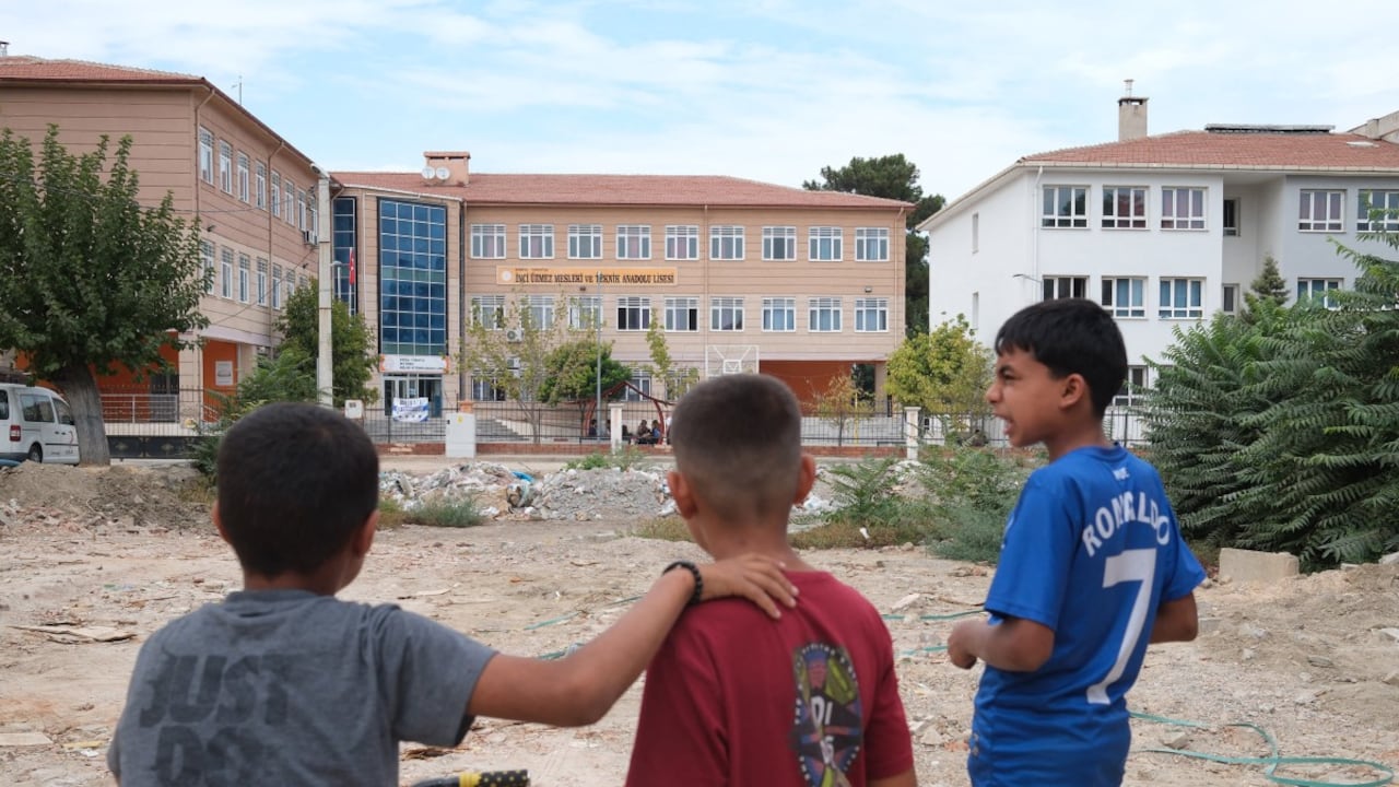 Niños observan una escuela secundaria donde un hombre armado abrió fuego hiriendo a once personas.