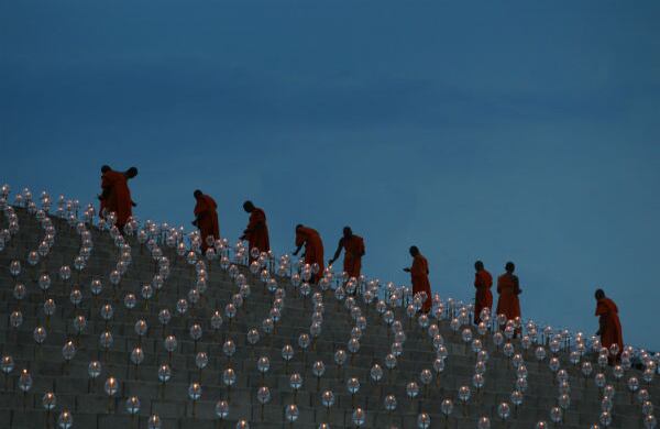 Los monjes budistas ponen luces sobre el domo de Wat Dhammakaya, durante las ceremonias para adorar a Buda en el sexto mes lunar, en Bangkok, Tailandia. (AP)