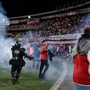 Momento en el que las unidades de seguridad retiran del campo de juego a los hinchas de Santa Fe tras los enfrentamiento con la barra del América.