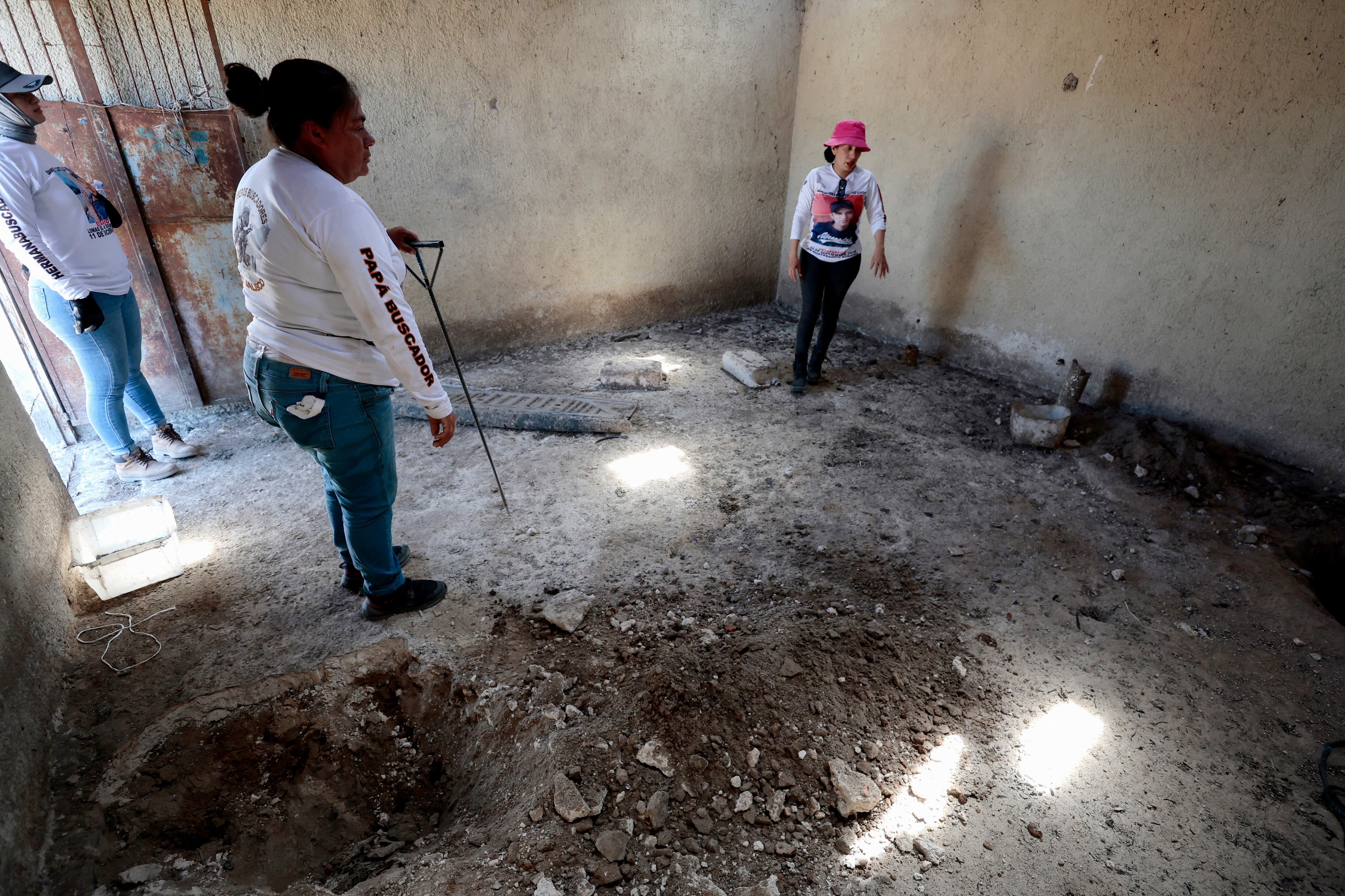 La líder del colectivo "Guerreros Buscadores", Indira Navarro (der.), gesticula mientras trabaja en una habitación del Rancho Izaguirre, en la comunidad de La Estanzuela, donde el colectivo localizó tres crematorios humanos mientras buscaban a sus familiares en Teuchitlán, Jalisco