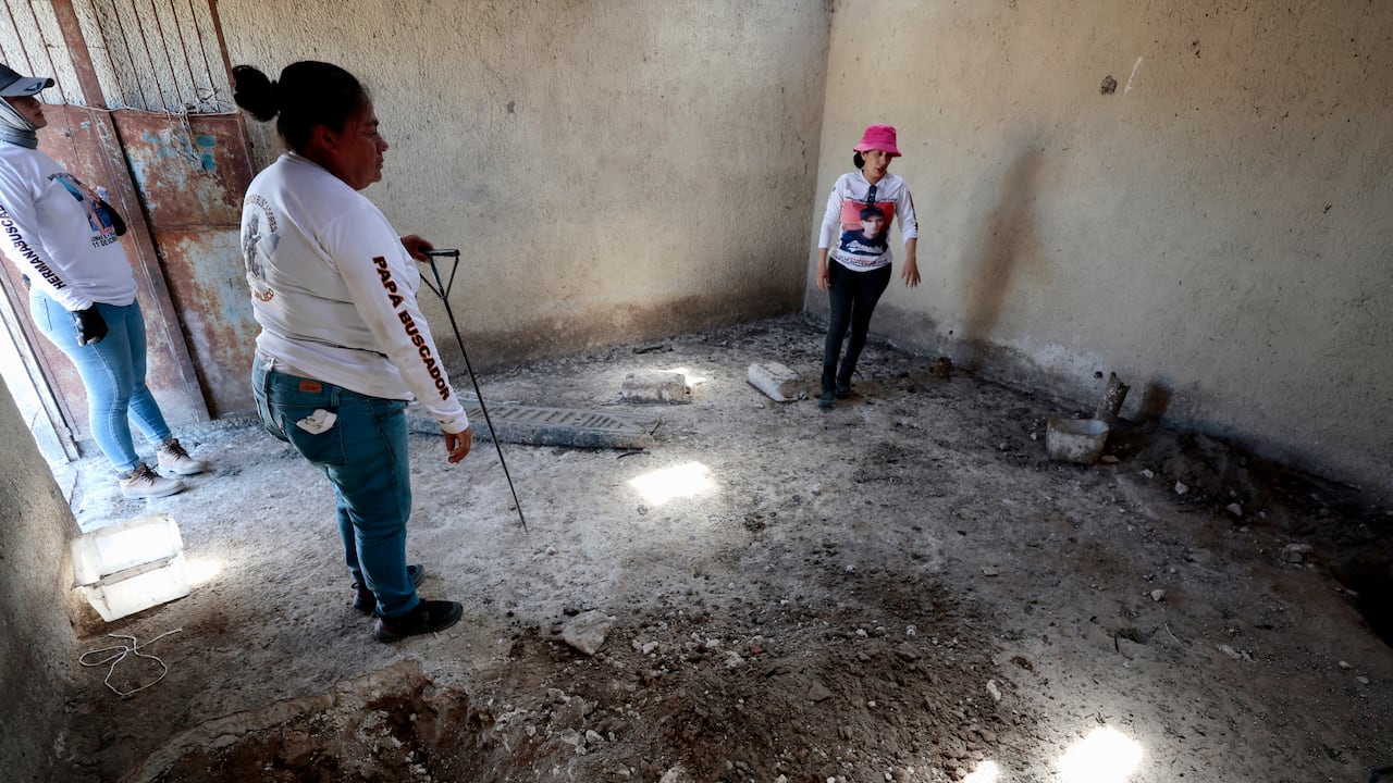 La líder del colectivo "Guerreros Buscadores", Indira Navarro (der.), gesticula mientras trabaja en una habitación del Rancho Izaguirre, en la comunidad de La Estanzuela, donde el colectivo localizó tres crematorios humanos mientras buscaban a sus familiares en Teuchitlán, Jalisco