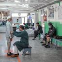 In this photograph taken on October 11, 2021, workers help a man try his new prosthetic leg at the International Committee of Red Cross Rehabilitation Centre in Kabul. - Just months ago they were fighting each other as mortal enemies, but today they are amputees dealing with their new disability, together. At this Red Cross-run rehabilitation centre in Kabul, former Afghan government soldiers and Taliban fighters adjust their new prostheses, living side by side. (Photo by BULENT KILIC / AFP) / TO GO WITH: Afghanistan-conflict-health-disability, FOCUS by Emmanuel Peuchot