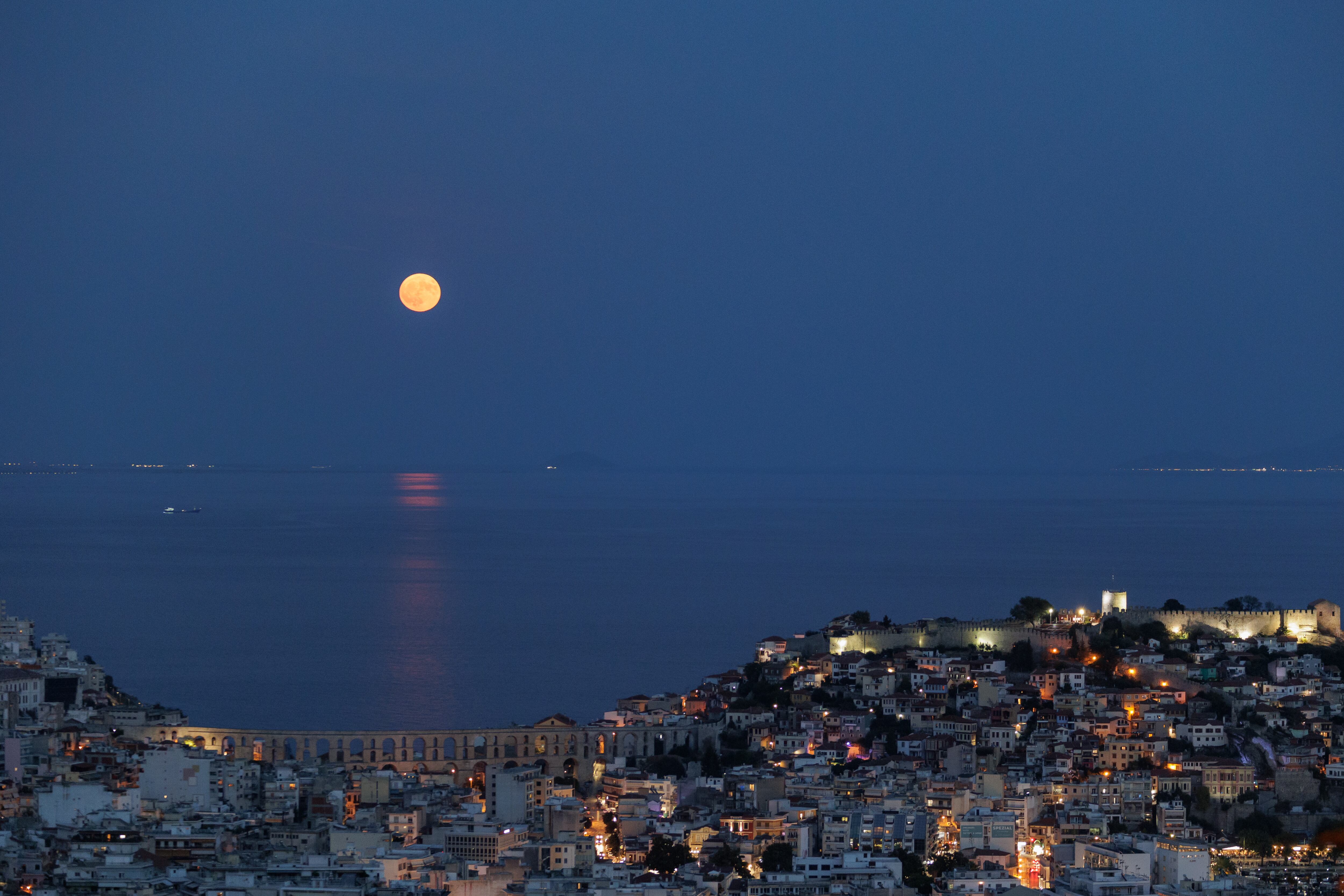 La superluna azul se eleva sobre la ciudad de Kavala, Grecia, el lunes 19 de agosto de 2024.