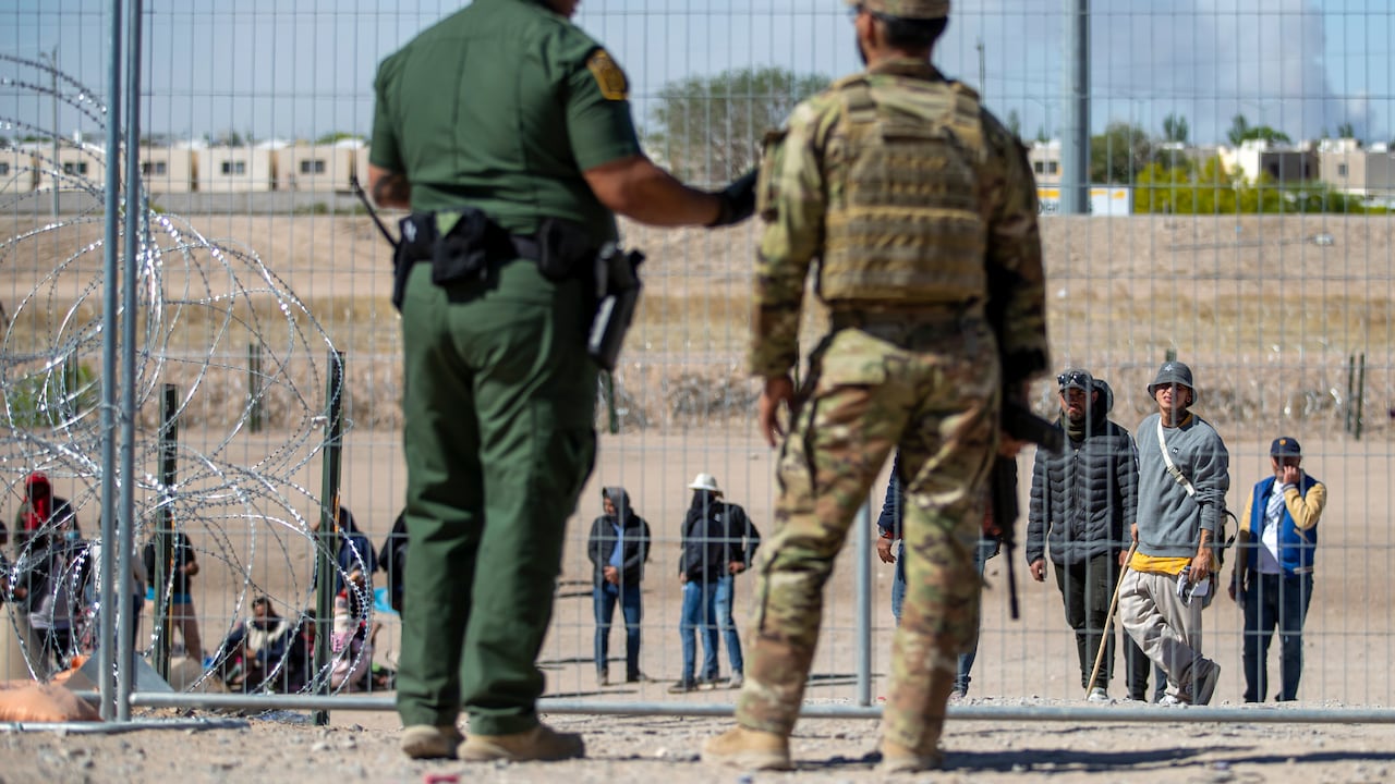 Migrantes aguardan a un costado del muro fronterizo vigilado por la Patrulla Fronteriza y la Guardia Nacional de Texas el miércoles 10 de mayo de 2023, con el fin de ingresar a El Paso, Texas. A partir del jueves, el gobierno del presidente Joe Biden comenzará a negarle el asilo a los migrantes que se presenten en la frontera con México sin primero haber presentado una solicitud en línea o pedido protección en el país por el que pasaron