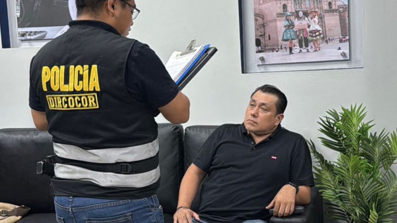 Esta fotografía, distribuida por la Policía Nacional del Perú, muestra la detención de José Edilberto Samame Blas (derecha), director de gestión electoral de la Oficina Nacional de Procesos Electorales (ONPE), por un agente de la policía anticorrupción en Lima el 13 de abril de 2026.