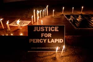 Candles are lighted near a placard calling for justice following the killing of Filipino journalist Percival Mabasa, also known as Percy Lapid, in Quezon City, Metro Manila, Philippines, on October 4, 2022. (Photo by Lisa Marie David/NurPhoto via Getty Images)
