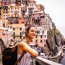 Turista relajante junto al mar. Ella está mirando la hermosa ciudad de Riomaggiore, Cinque Terre.