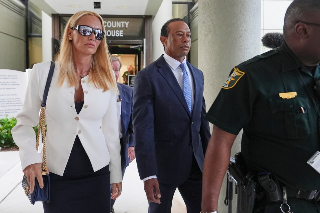 El golfista Tiger Woods (derecha) se marcha junto a Vanessa Trump (izquierda) tras la audiencia de declaración en el caso por conducción bajo los efectos del alcohol derivado de un accidente con vuelco ocurrido en Florida en marzo