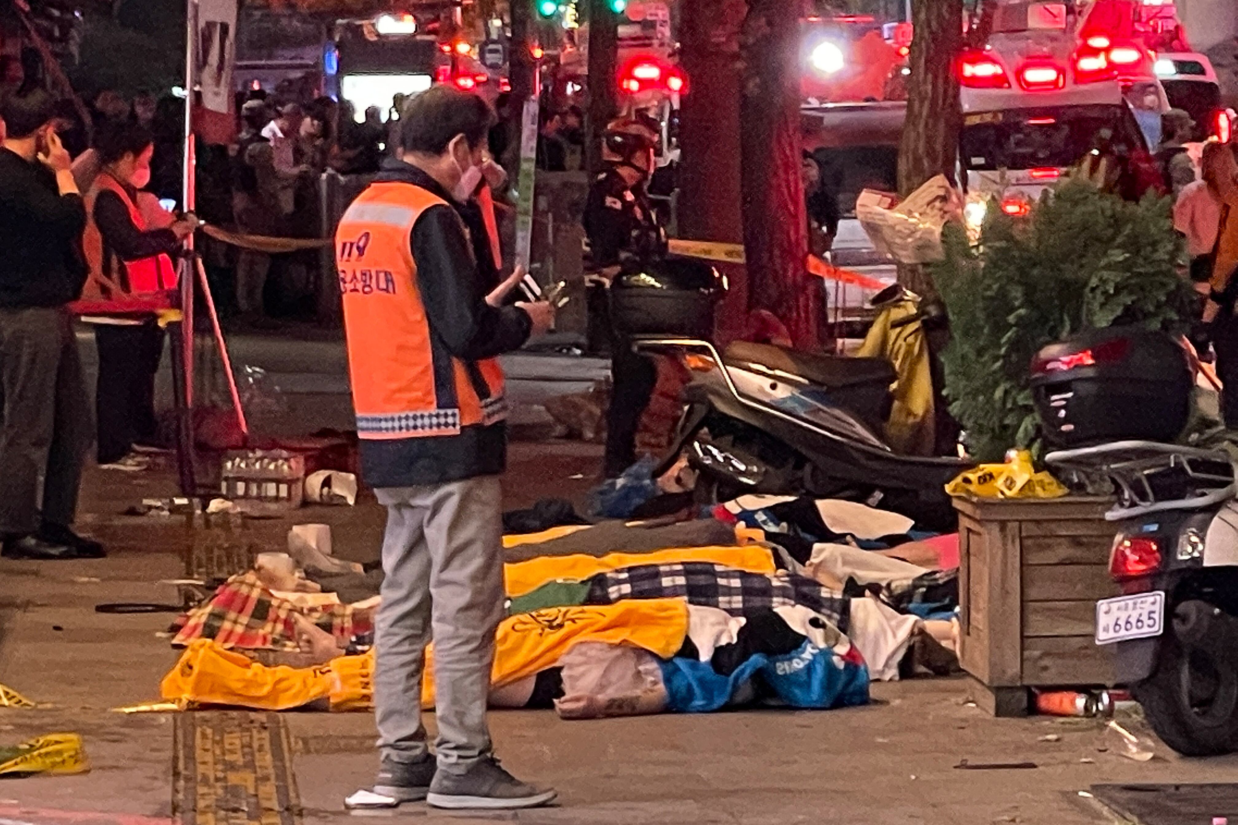 Los cuerpos de las víctimas, que se cree que sufrieron un paro cardíaco, están cubiertos con mantas en el popular distrito de vida nocturna de Itaewon en Seúl el 30 de octubre de 2022. - Decenas de personas sufrieron un paro cardíaco en la capital de Corea del Sur, Seúl. , después de que miles de personas se aglomeraran en las estrechas calles del barrio Itaewon de la ciudad para celebrar Halloween, dijeron funcionarios locales. (Foto de Yelim LEE / AFP)
