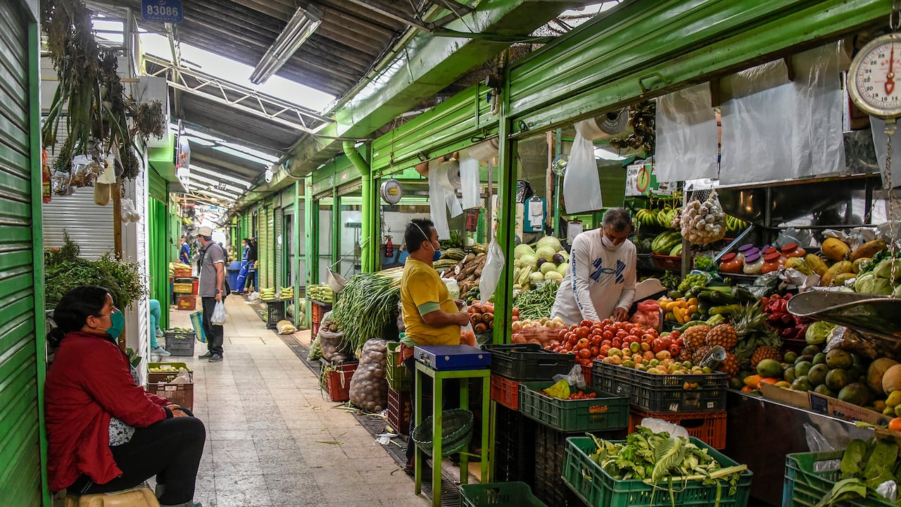 BOGOTA, COLOMBIA - MARCH 30: Customers wearing protective masks as a precaution against the spread of COVID-19 buy fruits and vegetables at the Paloquemao market on March 30, 2020 in Bogota, Colombia. Colombia started a national quarantine on March 25 until April 13 to control spread of COVID-19. The pandemic has spread to many countries across the world, claiming over 20,000 lives and infecting hundreds of thousands more. (Photo by Guillermo Legaria/Getty Images)