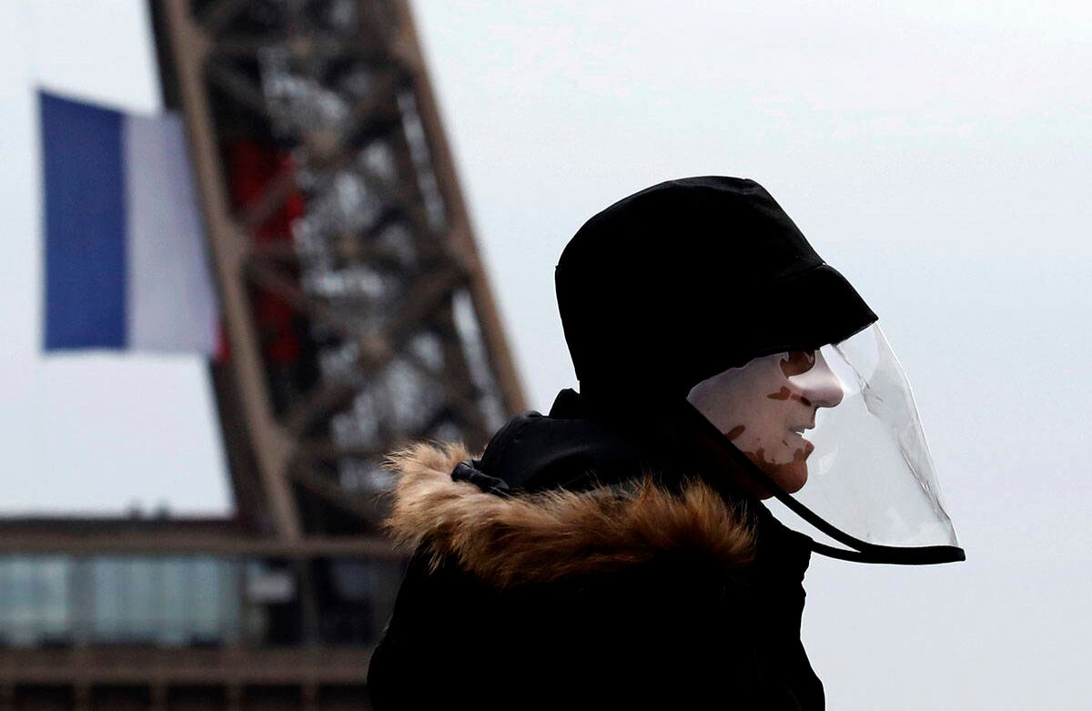 Un hombre usa una máscara protectora mientras camina cerca de la Torre Eiffel, en París, el lunes 11 de mayo de 2020. Foto: Christophe Ena/AP