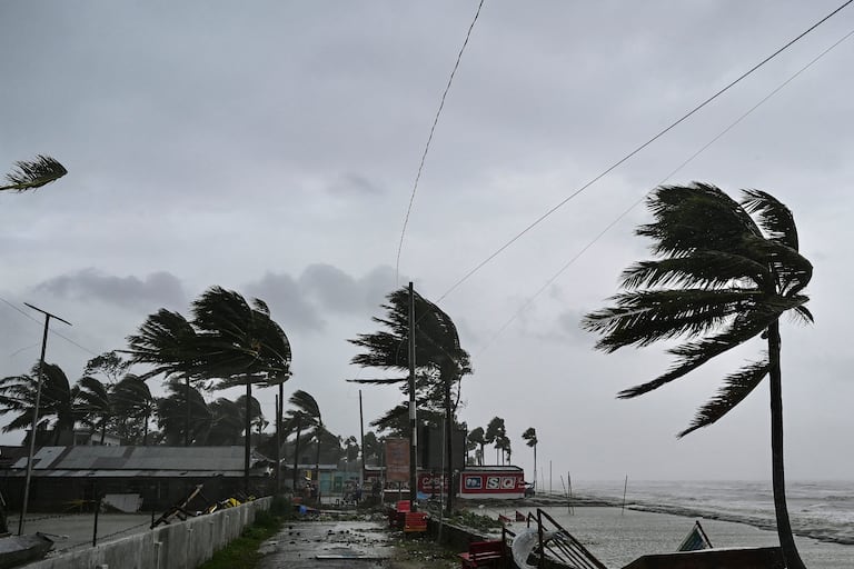 Los residentes de las zonas costeras bajas de Bangladesh y la India examinaron los daños el 27 de mayo cuando un intenso ciclón se debilitó hasta convertirse en una fuerte tormenta, con al menos dos personas muertas, tejados arrancados y árboles arrancados de raíz.
