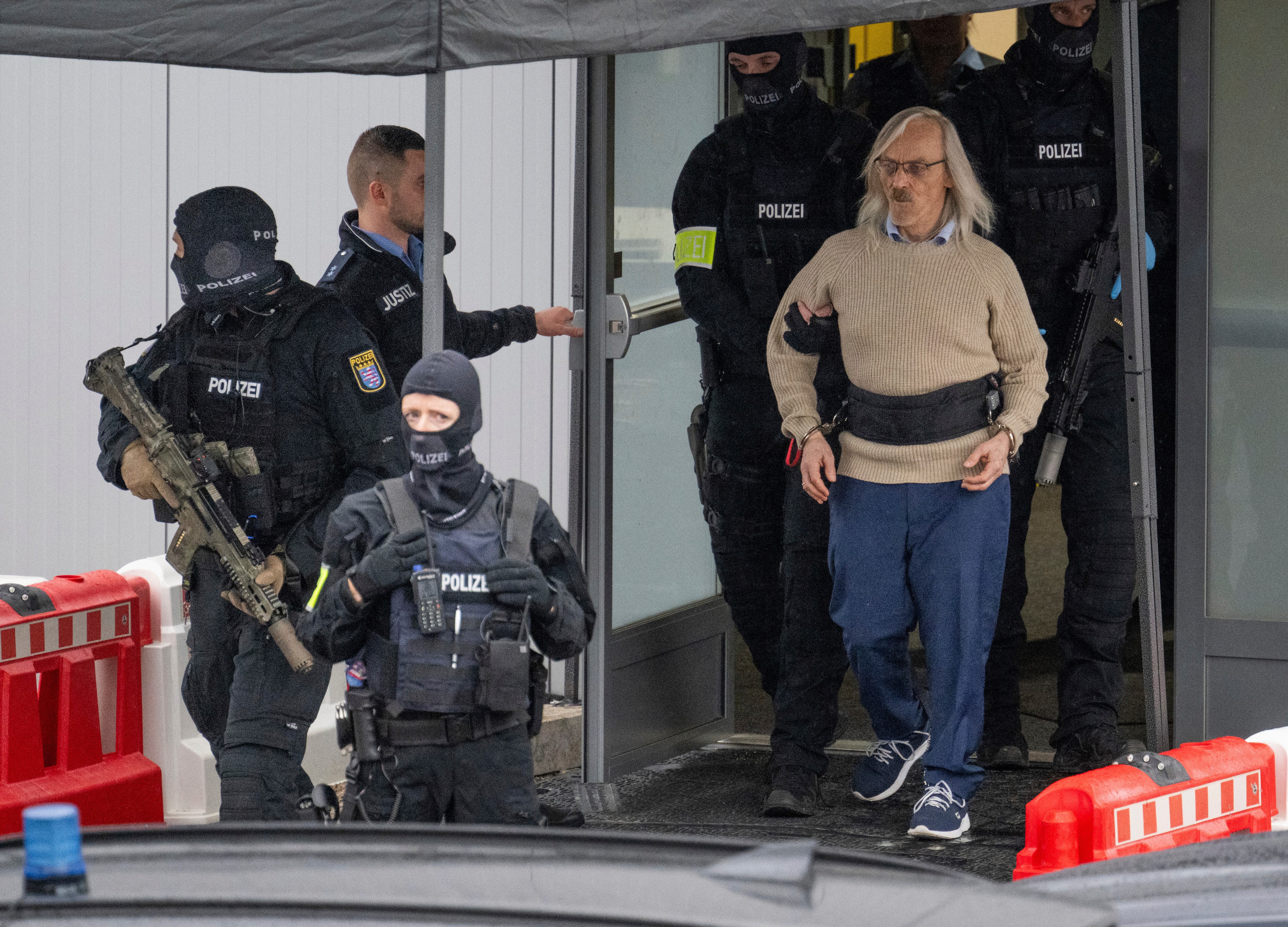 El acusado Maximilian Eder, segundo a la derecha, sale de una sala temporal construida para un juicio que comienza el martes en Frankfurt, Alemania, el martes 21 de mayo de 2024. Los presuntos líderes de un presunto complot de extrema derecha para derrocar al gobierno alemán fue juzgado en Frankfurt el martes, abriendo el proceso más destacado en un caso que conmocionó al país a finales de 2022.