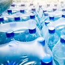 Muchas botellas de agua mineral azul envasadas en stock en una tienda o mercado.