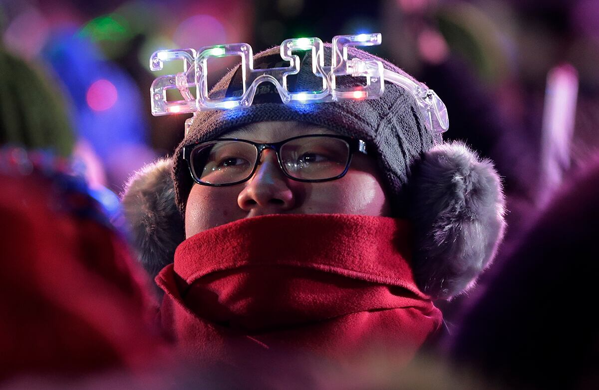 Un chino usa gafas que dicen “2015” mientras participa en la cuenta regresiva del año nuevo, frente al Estadio Nacional de Beijing, en China. (AP)