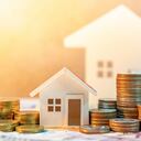 Inversión inmobiliaria o inmobiliaria. Tasa de préstamo hipotecario para vivienda. Ahorrar dinero para el concepto de jubilación. Pila de monedas en billetes internacionales con modelo de casa en la mesa. Fondo de crecimiento empresarial