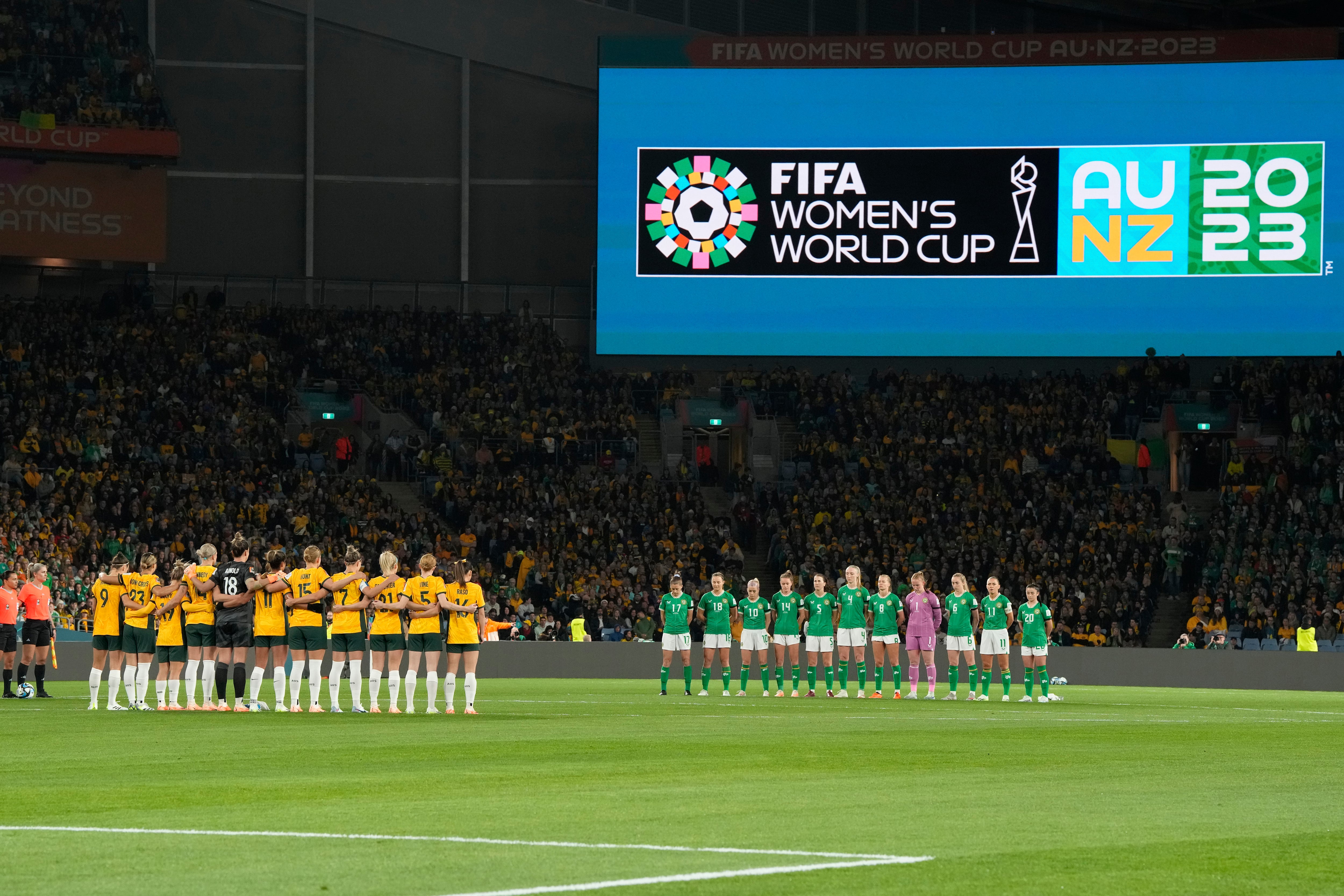 Las jugadoras de Australia, izquierda, e Irlanda guardan un momento de silencio por las víctimas del reciente tiroteo en Nueva Zelanda antes del partido de fútbol de la Copa Mundial Femenina entre Australia e Irlanda en el Estadio Australia en Sídney, Australia, el jueves 20 de julio de 2023. (Foto AP/Rick Rycroft)