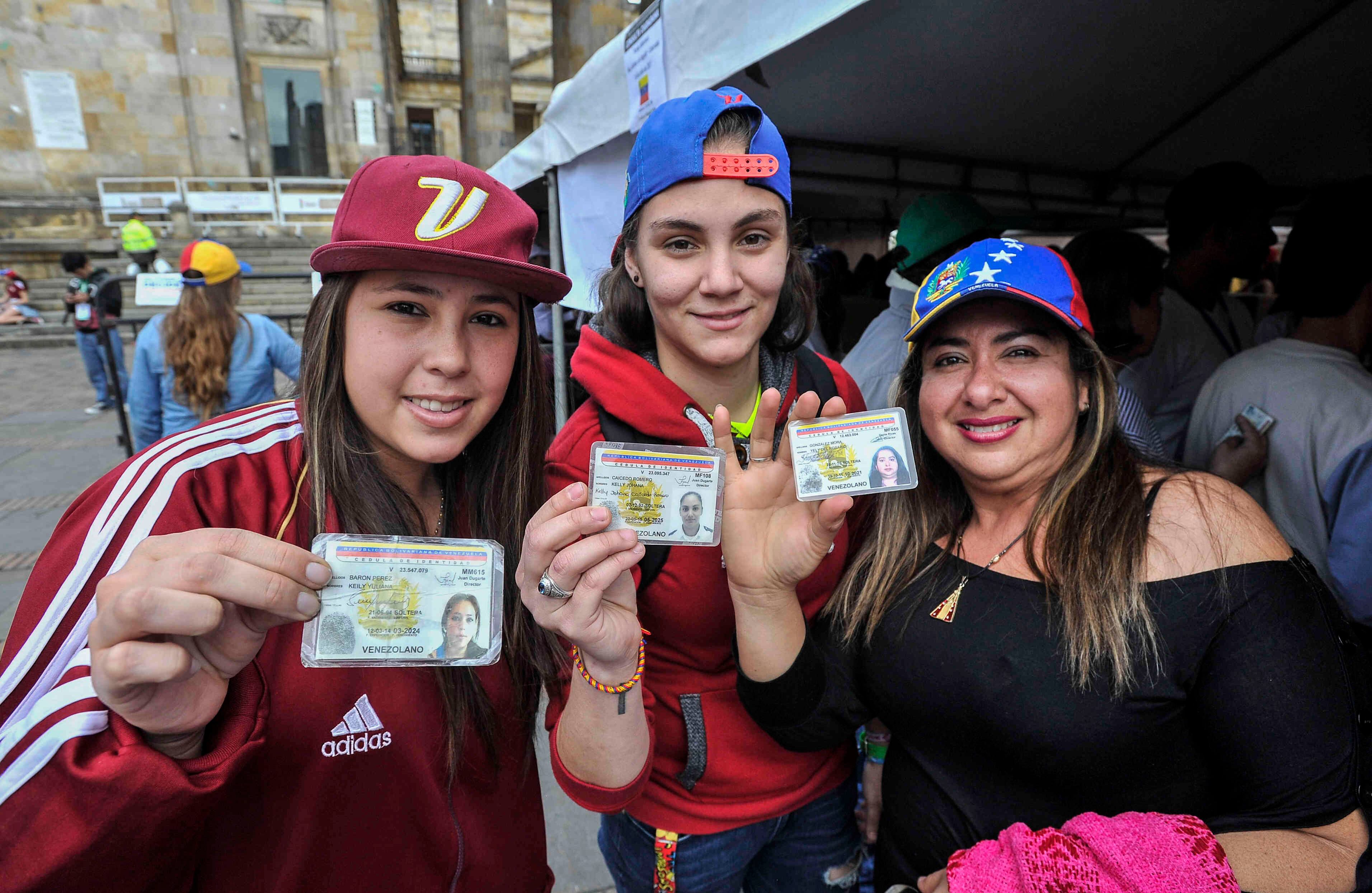 . Ciudadanas venezolanas —residentes en Bogotá— muestran su documento de identidad antes de sufragar en la Plaza de Bolívar,  el domingo 16 de julio de 2017 en Colombia, durante las votaciones al plebiscito. Esta jornada democrática ha sido  impulsada  por la oposición al gobierno de Nicolás Maduro. En las tarjetas, los ciudadanos deben responder ‘sí’ o ‘no’ a tres preguntas: la primera es si respalda el plan del presidente Nicolás Maduro de cambiar la Constitución; la segunda es si  apoya la intervención de las Fuerzas Armadas para “restituir el orden constitucional” y por último si desea un gobierno de unidad nacional. Foto: Carlos Julio Martínez 