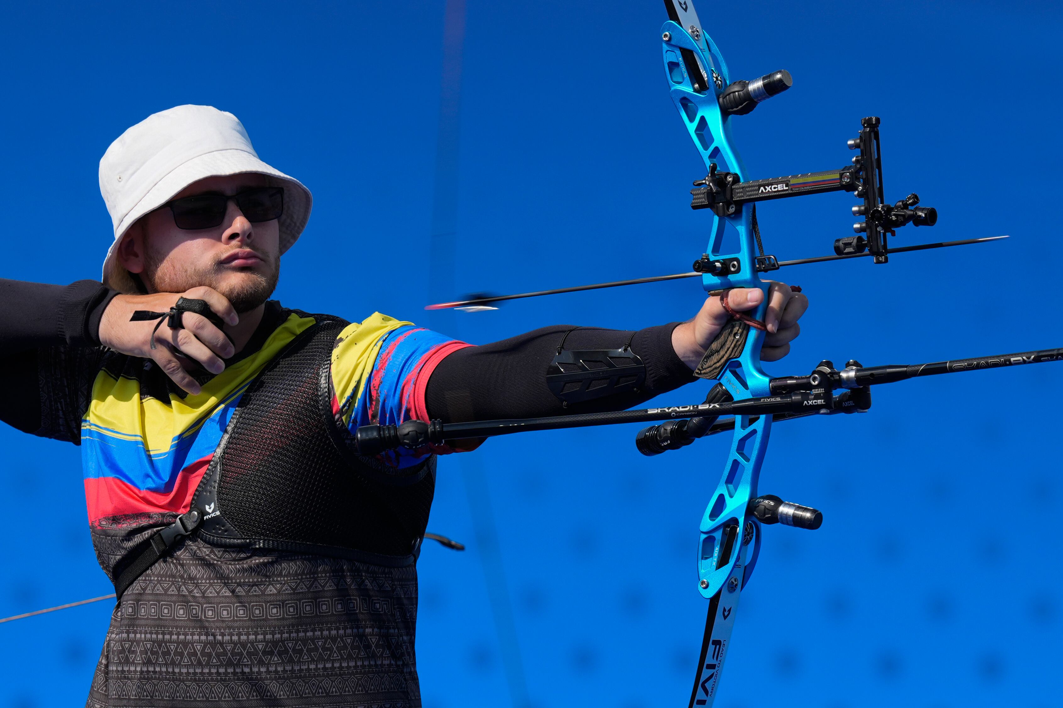 Colombia's Santiago Arcila releases his arrow in the men's team archery elimination round match between Colombia and Turkey at the 2024 Summer Olympics, Monday, July 29, 2024, in Paris, France. (AP Photo/Rebecca Blackwell)