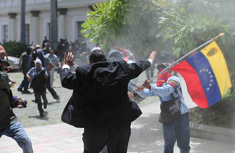 El legislador de la oposición, Franco Casella, es atacado por hombres enmascarados en un enfrentamiento con supuestos partidarios del gobierno que trataron de forzar su entrada en la Asamblea Nacional al final de una ceremonia conmemorativa del Día de la Independencia en Caracas el miércoles 5 de julio de 2017. Venezuela Está marcando 206 años de su declaración de independencia de España. (Fotos AP / Fernando Llano)