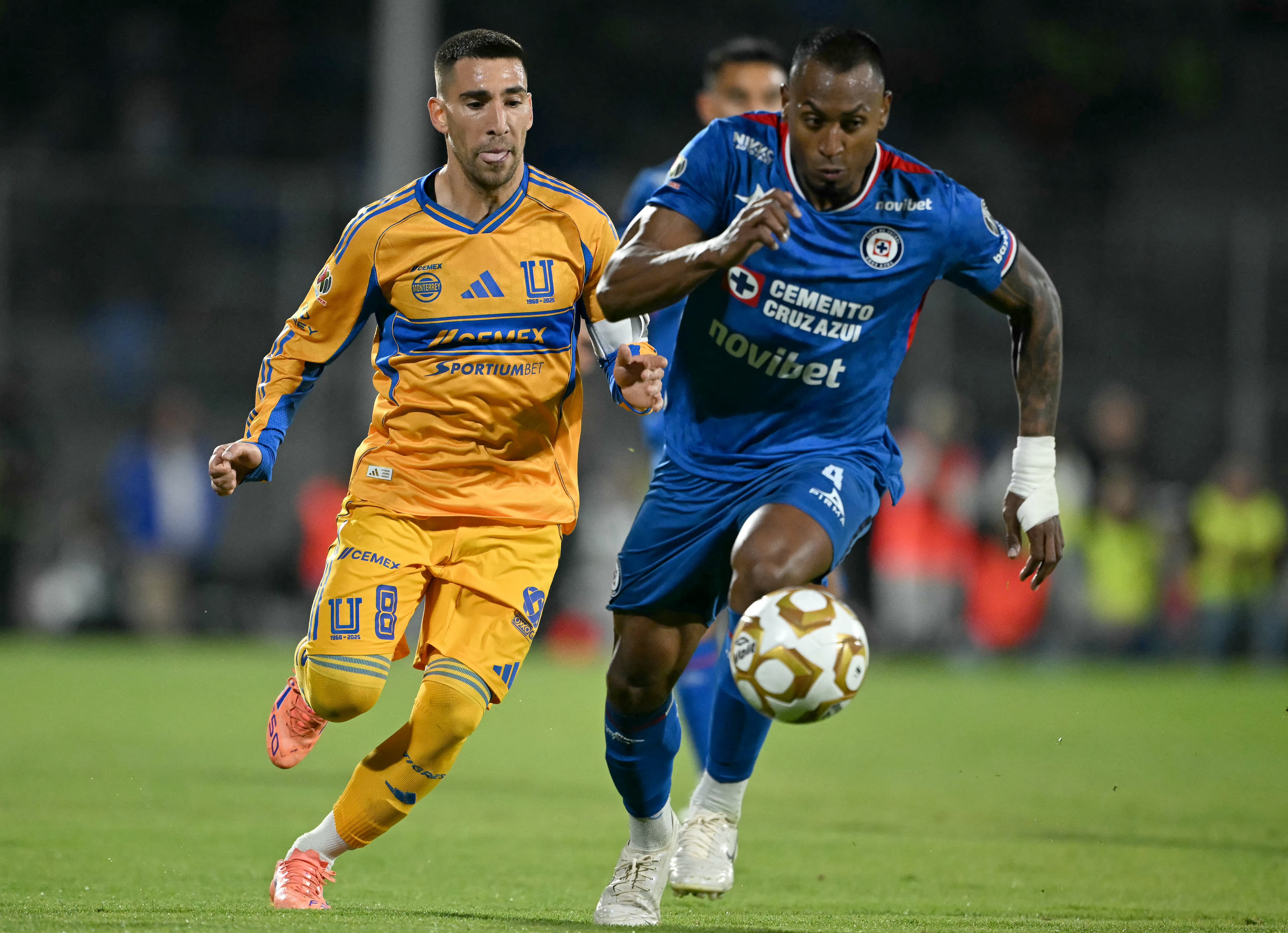 El mediocampista uruguayo de Tigres #08 Fernando Gorriarán (izq.) y el defensa colombiano de Cruz Azul #04 Willer Ditta disputan el balón durante el partido de ida de las semifinales del Apertura de la Liga MX entre Cruz Azul y Tigres en el Estadio Banorte en la Ciudad de México el 3 de diciembre de 2025. (Foto de CARL DE SOUZA / AFP)
