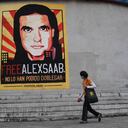 Una mujer pasa junto a un cartel que exige la libertad del empresario colombiano Alexander Saab, quien fue extraditado a Estados Unidos, en Caracas, el 17 de octubre de 2021. - La oposición venezolana pidió al gobierno del presidente Nicolás Maduro que reanude las conversaciones para resolver sus diferencias, luego de la El partido gobernante se retiró de la última ronda que iba a comenzar el domingo en México. (Foto de Federico PARRA / AFP)