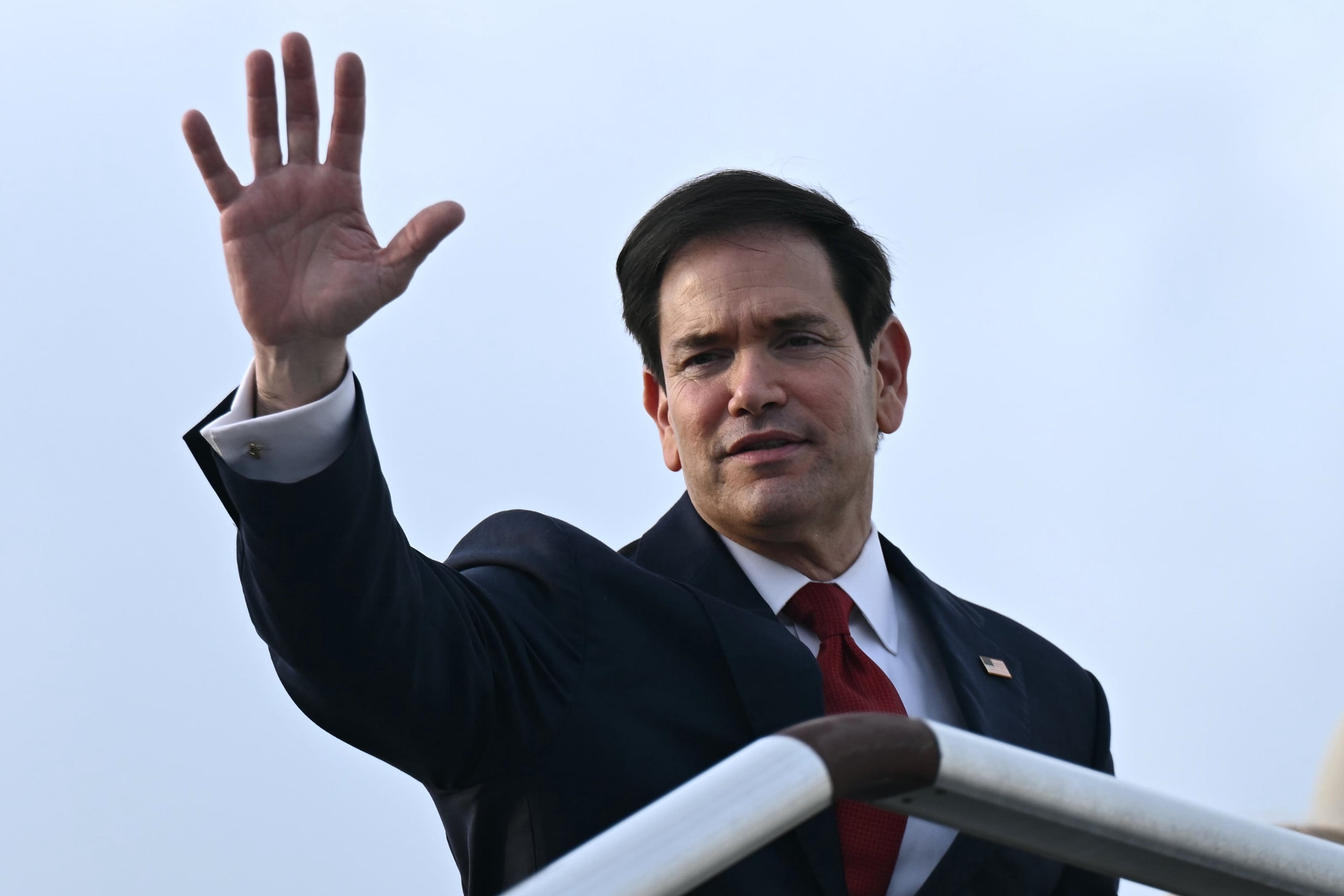 El secretario de Estado Marco Rubio saluda desde lo alto de la escalerilla de su avión para partir en el Aeropuerto Internacional Ninoy Aquino en Manila, Filipinas.