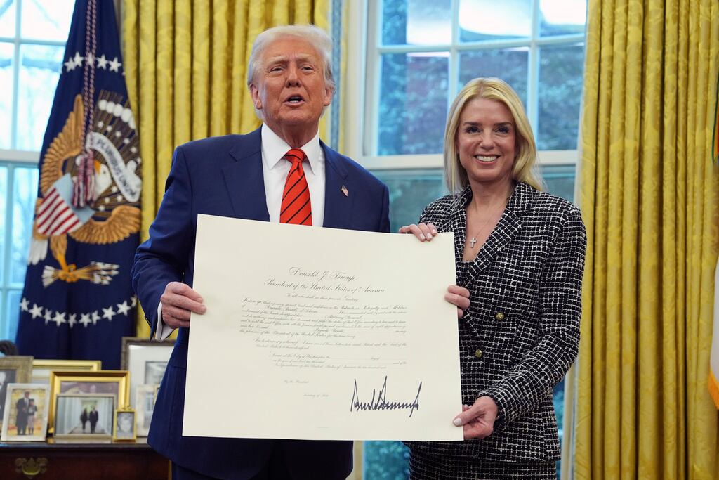 El presidente Donald Trump presenta un documento a la fiscal general Pam Bondi, después de que ella prestara juramento ante el juez asociado de la Corte Suprema Clarence Thomas, en la Oficina Oval de la Casa Blanca, el miércoles 5 de febrero de 2025, en Washington. (Foto AP/Evan Vucci)