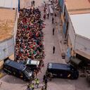 Los menores no acompañados que cruzaron a España están reunidos fuera de un almacén utilizado como refugio temporal mientras esperan ser examinados para COVID-19 en el enclave español de Ceuta, cerca de la frontera entre Marruecos y España, el miércoles 19 de mayo de 2021. Servicios sociales para la pequeña ciudad encaramada en un afloramiento en el Mediterráneo se hundió bajo la presión después de que más de 8.000 personas cruzaran a territorio español durante los dos días anteriores. (Foto AP / Bernat Armangue)