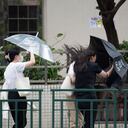 In this photo released by Xinhua News Agency, residents walk against strong wind and rain as Typhoon Talim approaches in Macao in southern China on Monday, July 17, 2023. Schools and the stock market were closed in Hong Kong on Monday as Typhoon Talim sideswiped the city and headed toward landfall on the Chinese mainland and the island province of Hainan. (Cheong Kam Ka/Xinhua via AP)