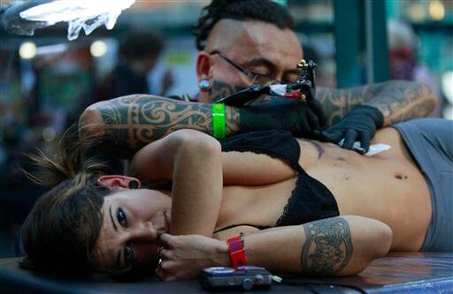 Artistas del tatuaje muestran sus técnicas al público mientras elaboran sus diseños