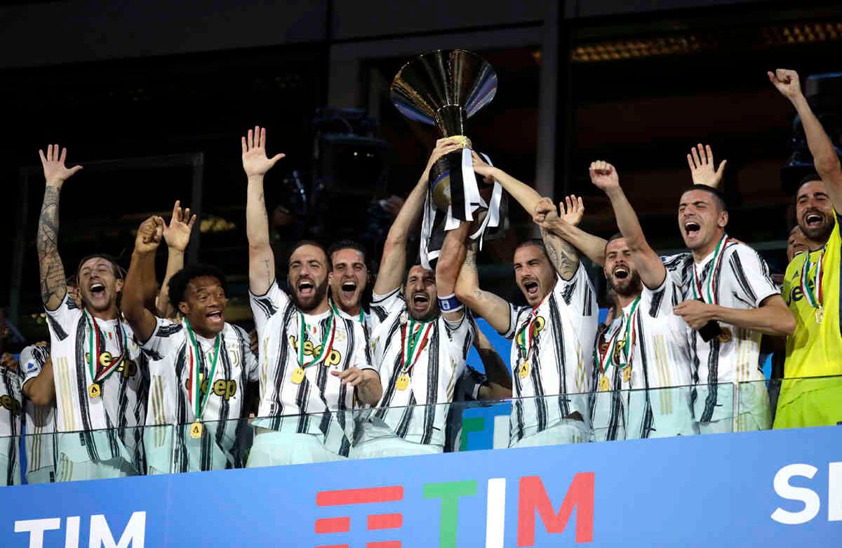Los jugadores de la Juventes, Giorgio Chiellini y Leonardo Bonucci, sostienen el trofeo del noveno título consecutivo de fútbol de la Serie A italiana, un hecho sin precedentes en el fútbol de este país. Imagen tomada al final del partido entre la Juventus y Roma, en el estadio Allianz de Turín, el sábado 1 de agosto. Foto: Luca Bruno / AP