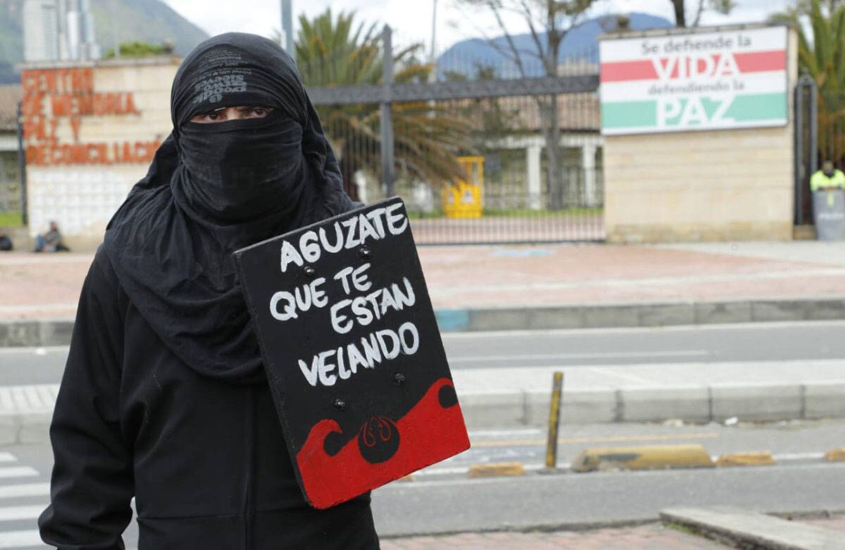 Uno de los manifestantes sostiene un cartel a las afueras del Centro de Memoria Paz y Reconciliación en Bogotá. Foto Guillermo Torres / Semana